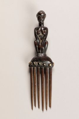 un peigne en bois sur lequel est assise une femme