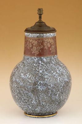 un vase muni d'un couvercle posé sur une table