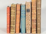 plusieurs vieux livres sont alignés sur une surface blanche