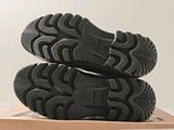 pair of black shoes sitting on top of a box on a white surface