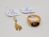 two gold rings and a gold elephant charm on a white surface