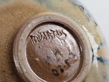 a close up of a vase with a brown lid