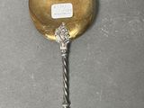a silver spoon with a gold handle on a table