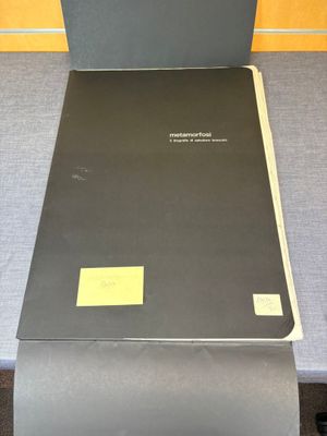 un dossier noir sur lequel est collé un autocollant jaune, posé sur une table
