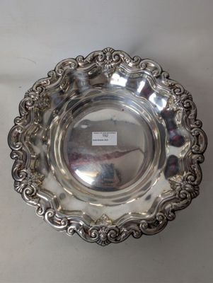 an antique silver plate with a decorative design on the rim