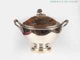 a silver bowl with a lid on a white surface