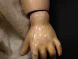 a wooden doll with a hand on it ' s arm