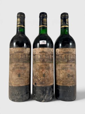 trois bouteilles de vin posées les unes à côté des autres sur une surface blanche