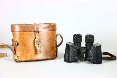 un étui en cuir marron et une paire de jumelles
