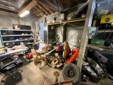 un garage où le sol est encombré d'objets divers et de bric-à-brac
