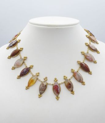un collier orné de pierres multicolores sur un mannequin blanc