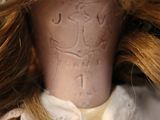 a close up of a doll with a hat on