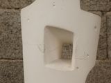 a white toilet that has a hole in the side of it