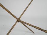 a metal sculpture of bamboo sticks on a white surface