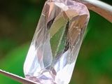 un diamant rose maintenu par une paire de pinces