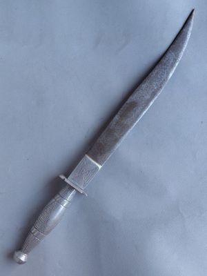 un couteau posé sur une surface blanche