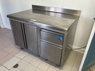 un plan de travail en acier inoxydable dans une cuisine dotée d'une porte bleue