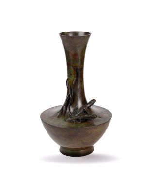 a bronze vase that is sitting on a white surface