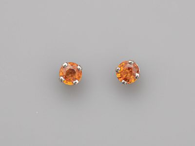 une paire de boucles d'oreilles à clous en saphir orange