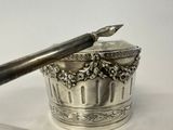 a silver container with a pen and a knife on it