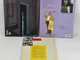 an open book sitting on top of a white table next to a black and yellow book