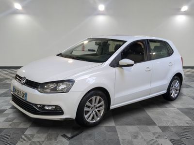 une Volkswagen Polo break blanche garée dans une pièce au sol carrelé