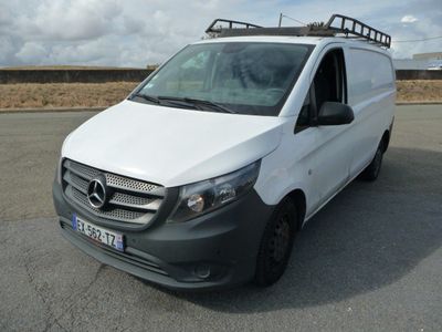 La camionnette blanche est garée sur un parking ; elle est équipée d'une galerie de toit.