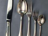 five spoons, a knife, and a fork on a table