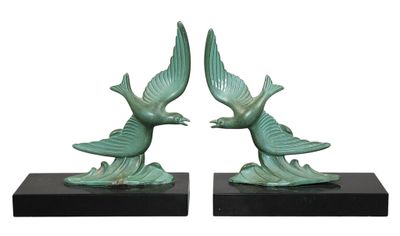 pair of green bird sculptures on black bases on a white background