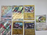 un tas de cartes Pokémon posées sur une surface blanche