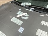 a sticker on the hood of a car that is parked in a parking lot