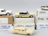 quatre petites voitures sont posées sur des cartons