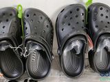 trois paires de Crocs noires sont alignées les unes à côté des autres