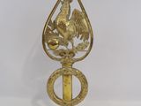 a gold rooster on top of a brass object