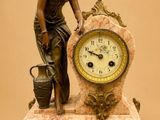 a statue of a woman standing next to a clock