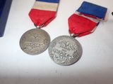 two medals sitting on a table next to each other