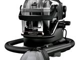 La photo en noir et blanc montre un aspirateur et un plumeau.