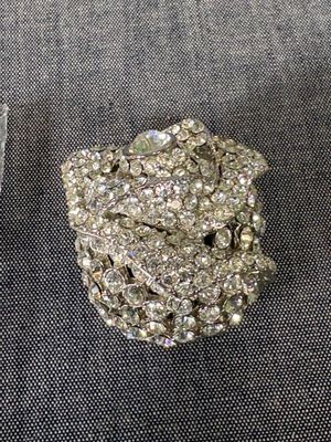 une broche en argent posée à côté d'une paire de ciseaux