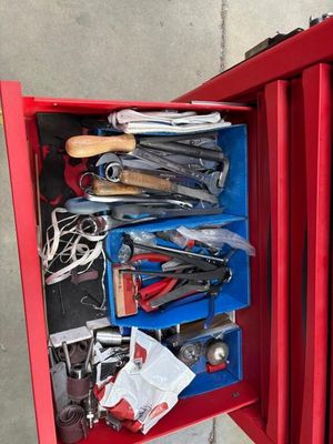 une boîte rouge contenant des outils sur le sol