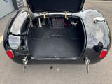 a black car with its trunk open in a parking lot
