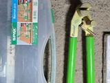 a plastic container with a green handle and a pair of pliers next to it