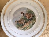a plate with two birds painted on it on a table