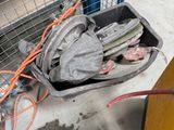 une boîte posée par terre, contenant tout un tas d'outils