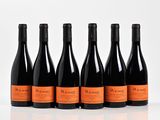 six bottles of wine are lined up in a row on a white surface