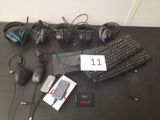 plusieurs casques audio, un clavier, une souris et un téléphone portable posés sur une table