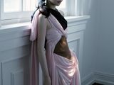 a woman that is standing by a window in a dress