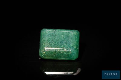 un gros plan d'une émeraude verte sur une surface noire