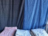 many folded towels on a shelf next to a shower curtain