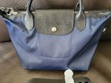 a blue and black purse with a keychain on a brown couch