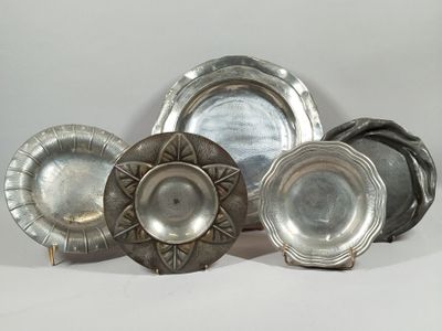 a group of silver plates sitting on a white surface